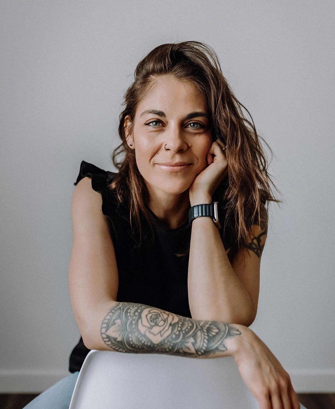 Studio portraits showing playful expressions and tattoo art against grey backdrop.
