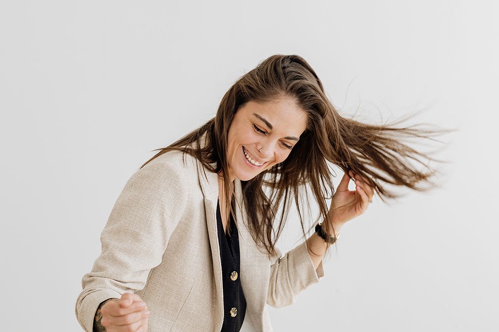 Lifestyle portraits showing movement and joy in cream colored blazer against white background.