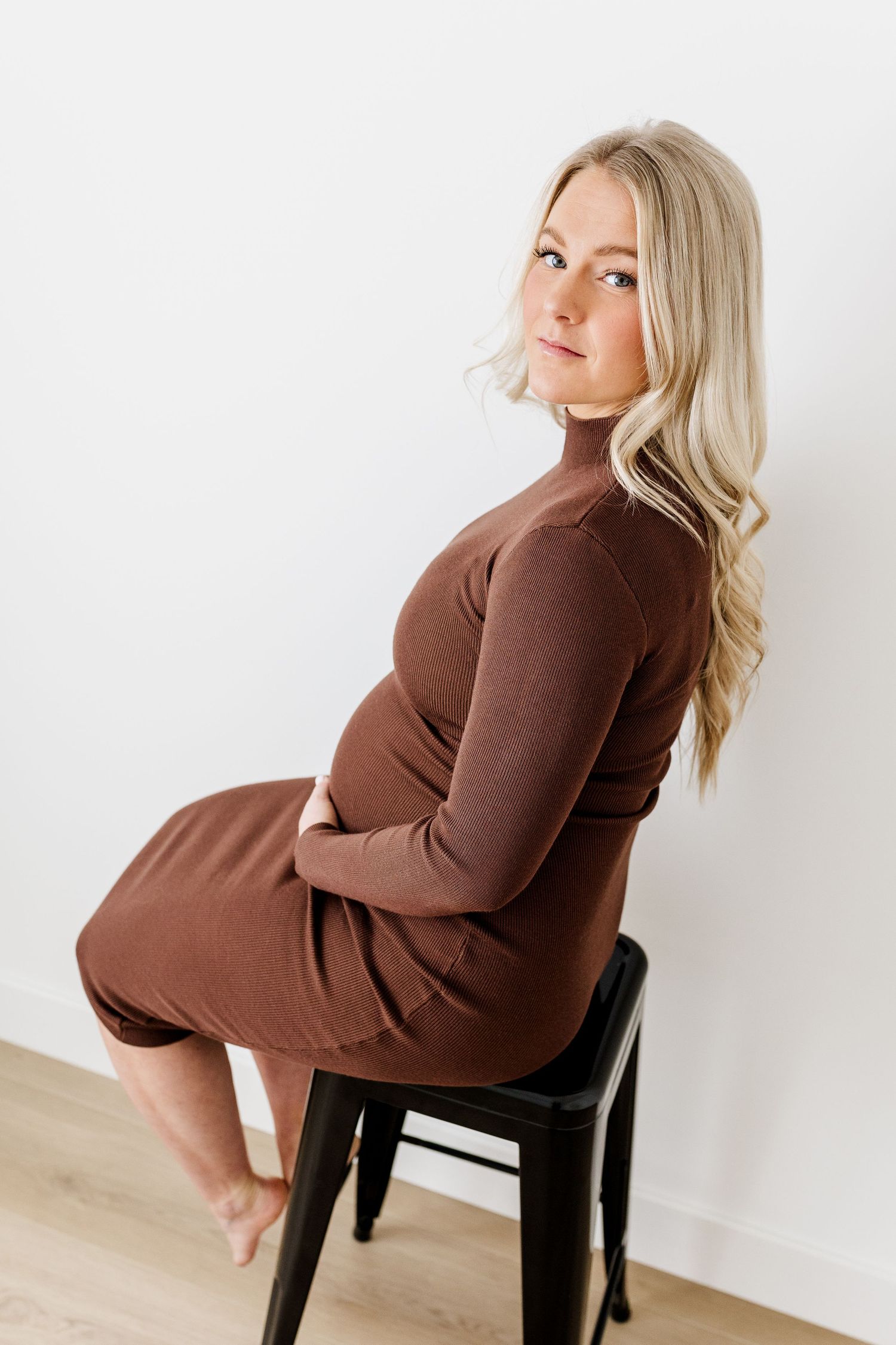 Artistic maternity portraits featuring brown dress and natural lighting.
