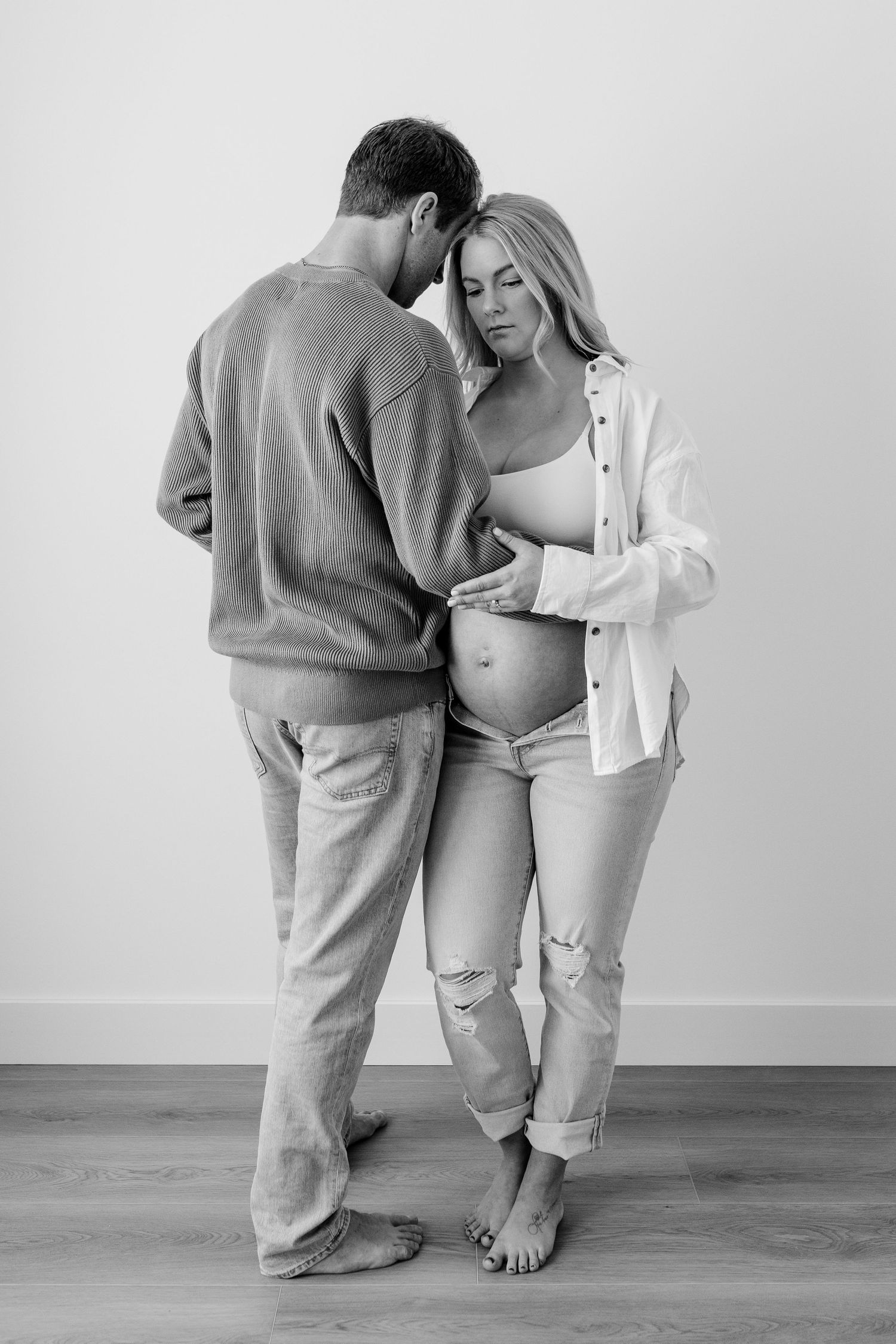 Black and white series of intimate couple poses in minimalist setting.