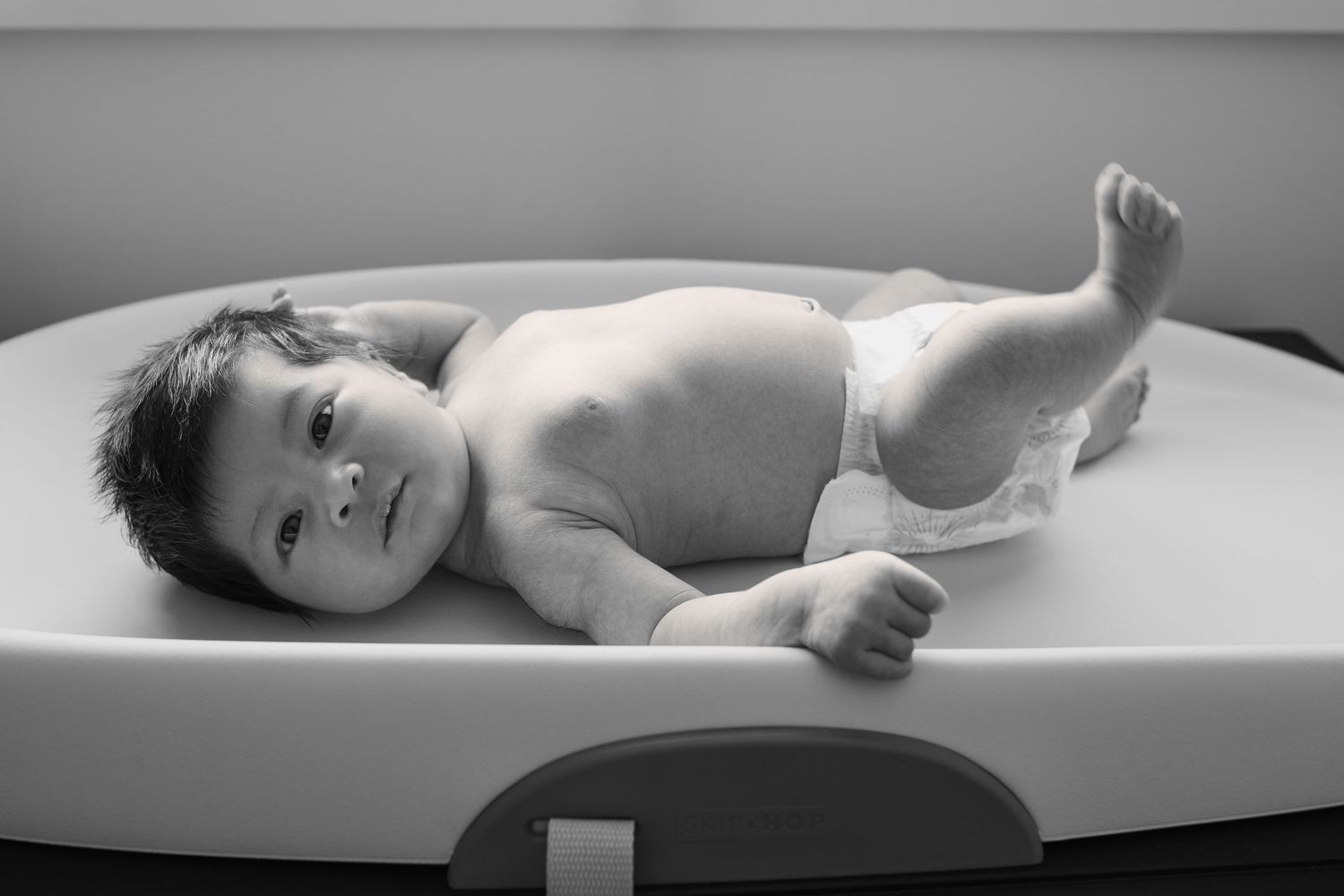 Black and white artistic portrait of newborn baby during professional photo session.