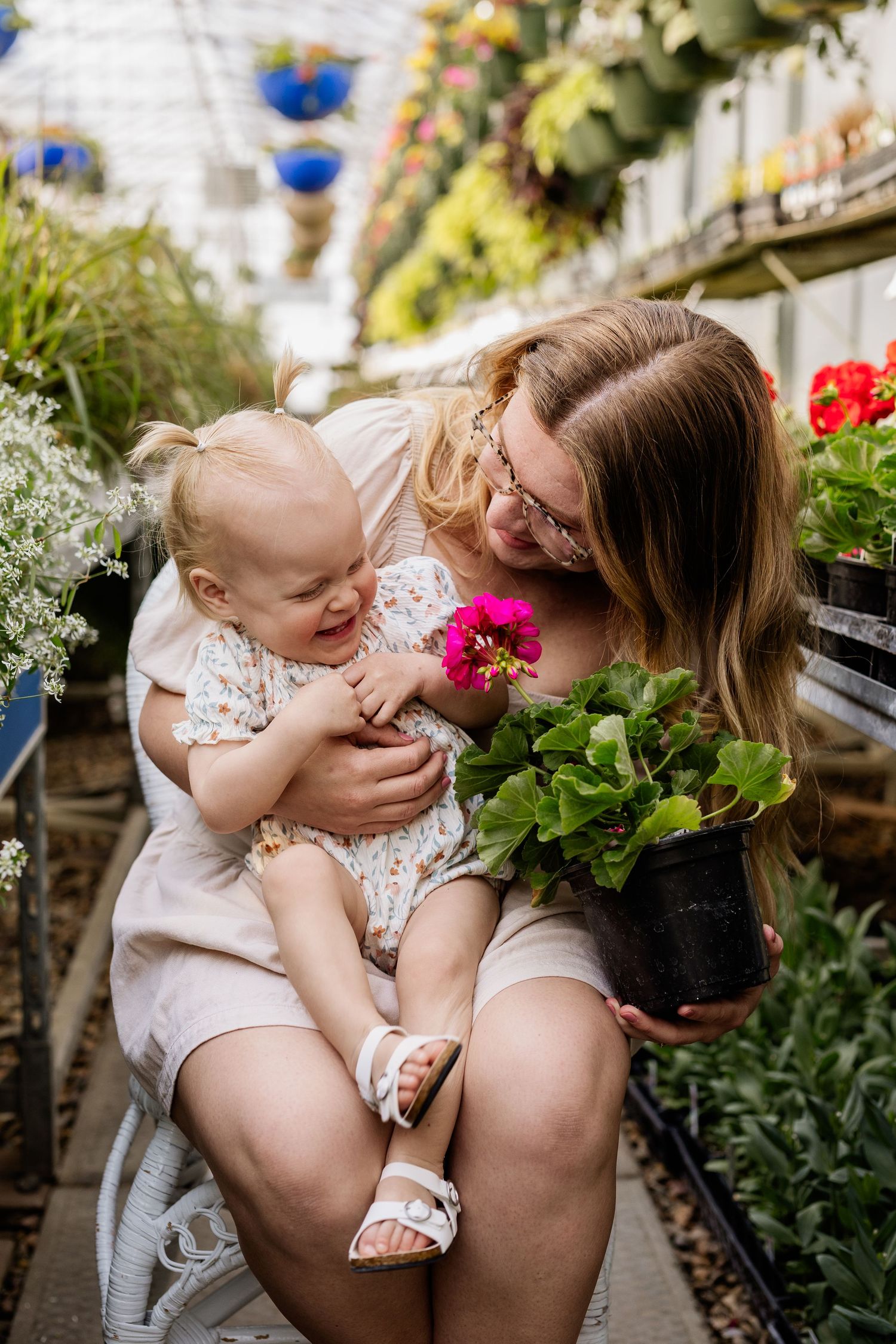 Sweet candid moments shared between parent and child among blooming flowers.