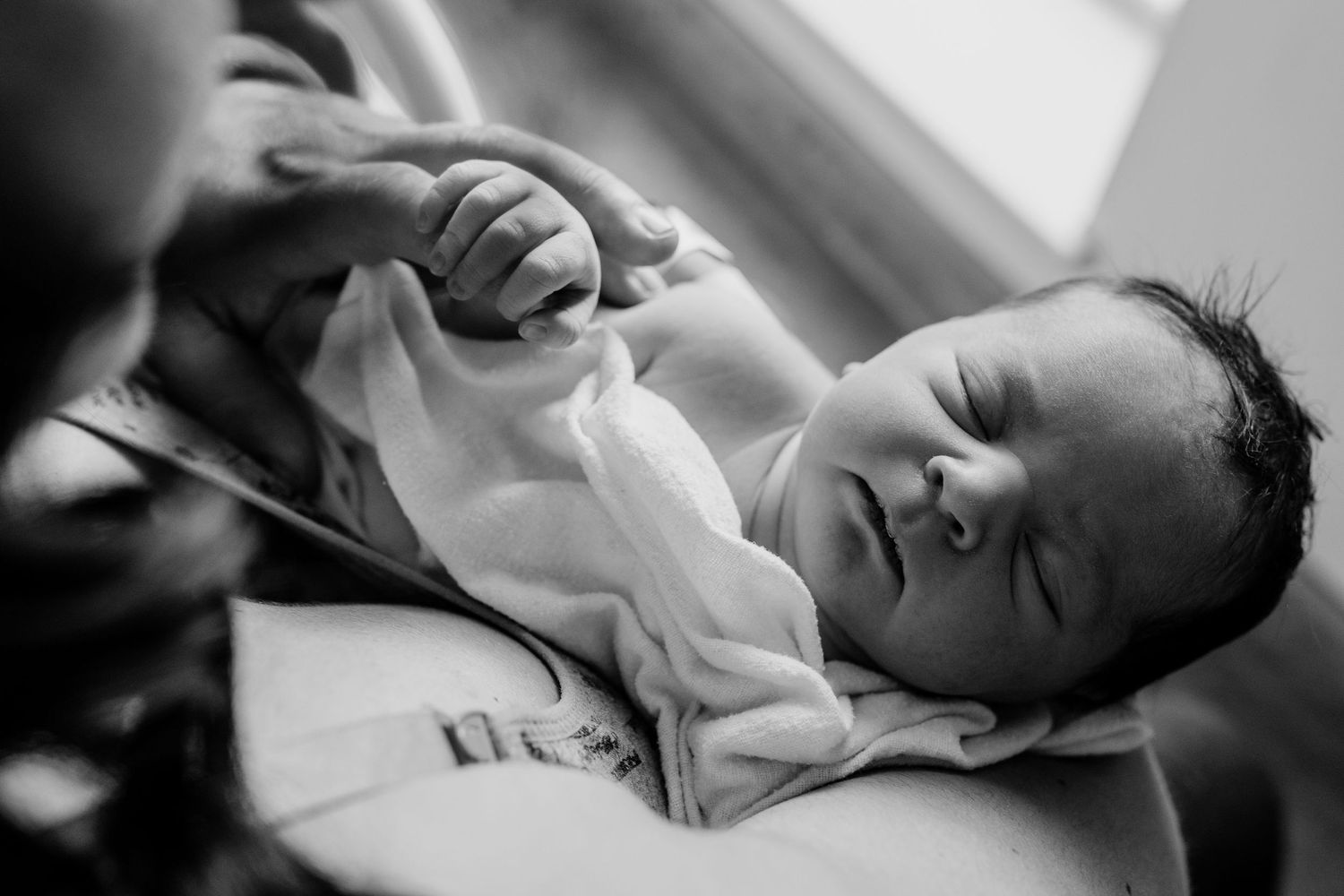 Black and white close-up portraits of a sleeping newborn baby in hospital.