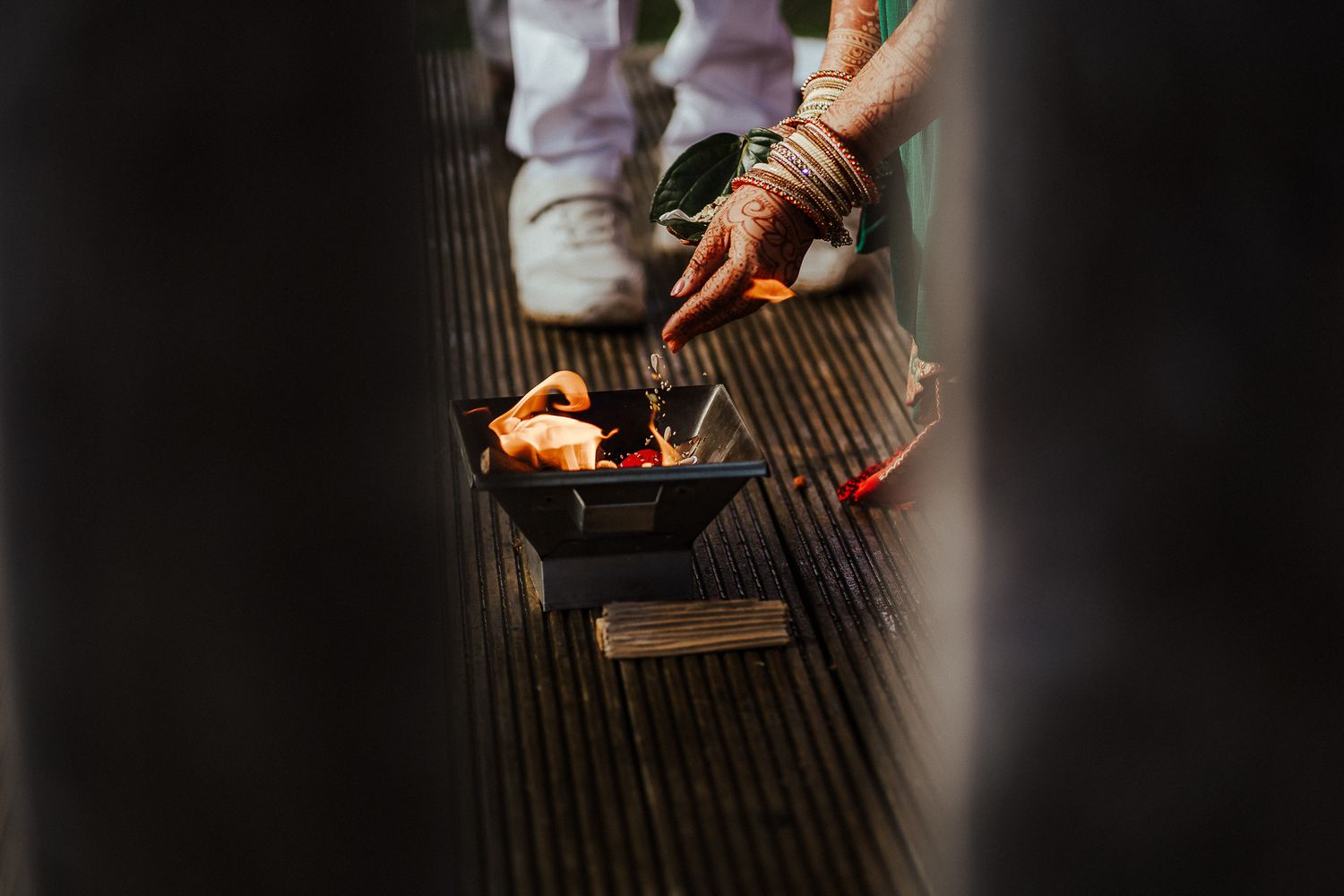 Close-up shot of hands performing a traditional ceremony ritual with burning incense.