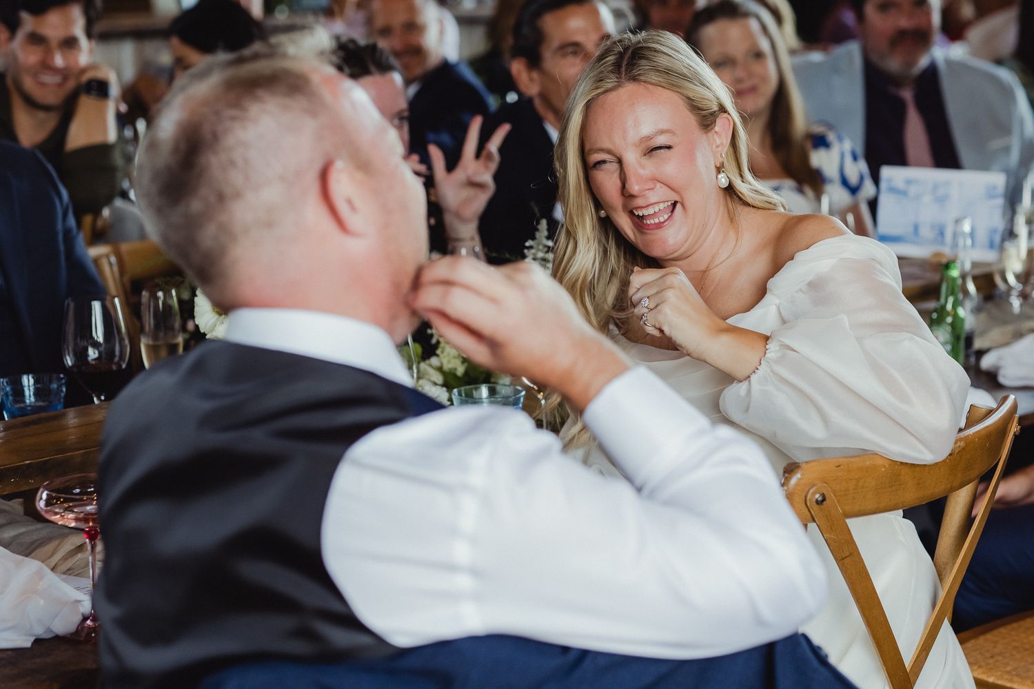 Candid moments from a wedding reception show guests laughing and celebrating at tables in a restaurant setting.