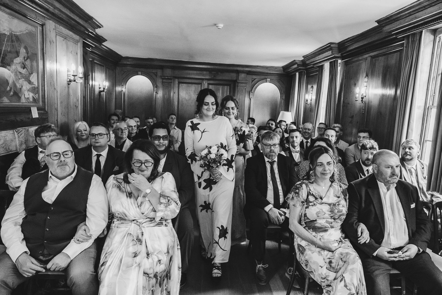 A series of candid black and white wedding reception photos showing guests mingling and dancing in an elegant venue.