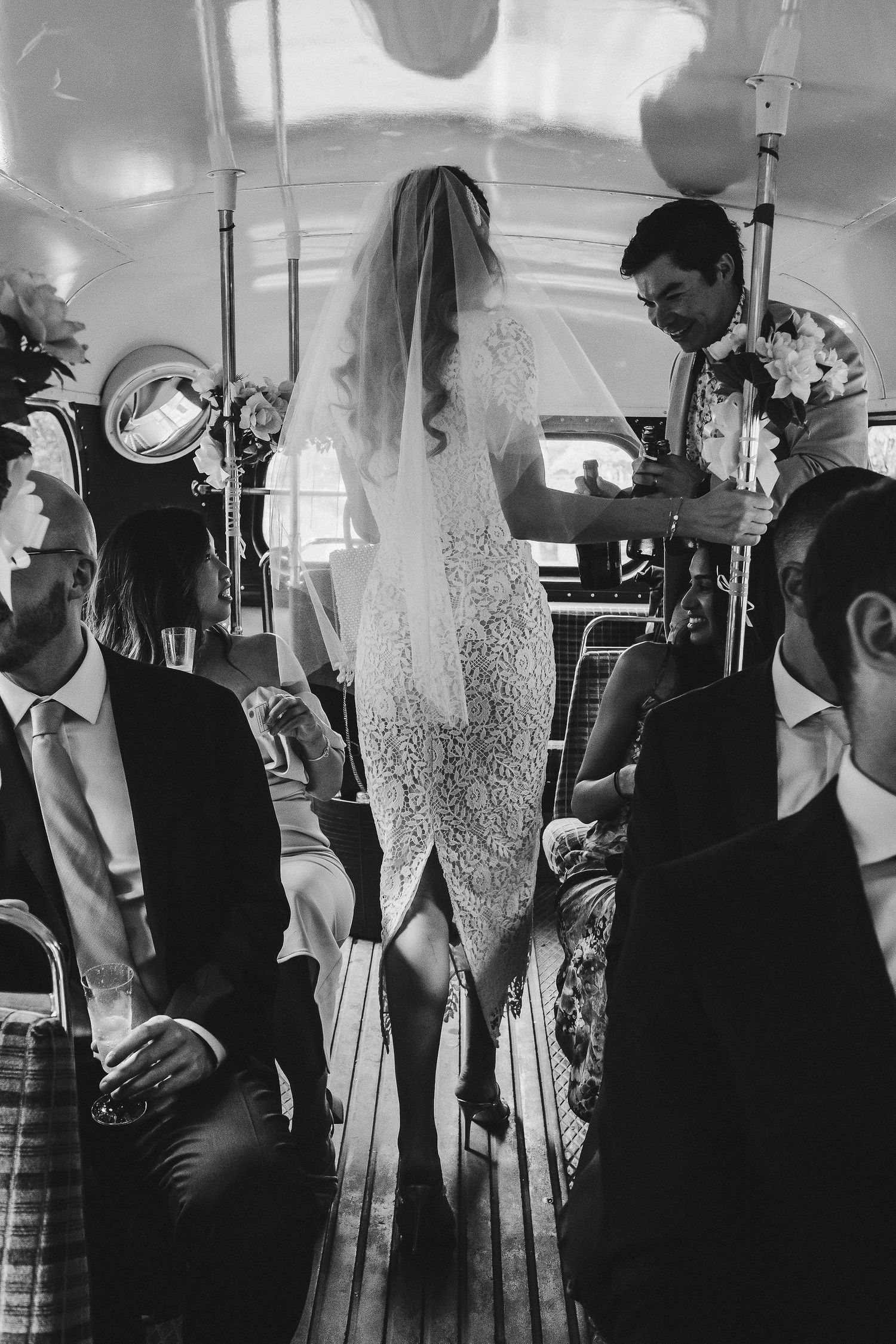 Black and white wedding photos showing candid moments between guests and the wedding party during a reception.