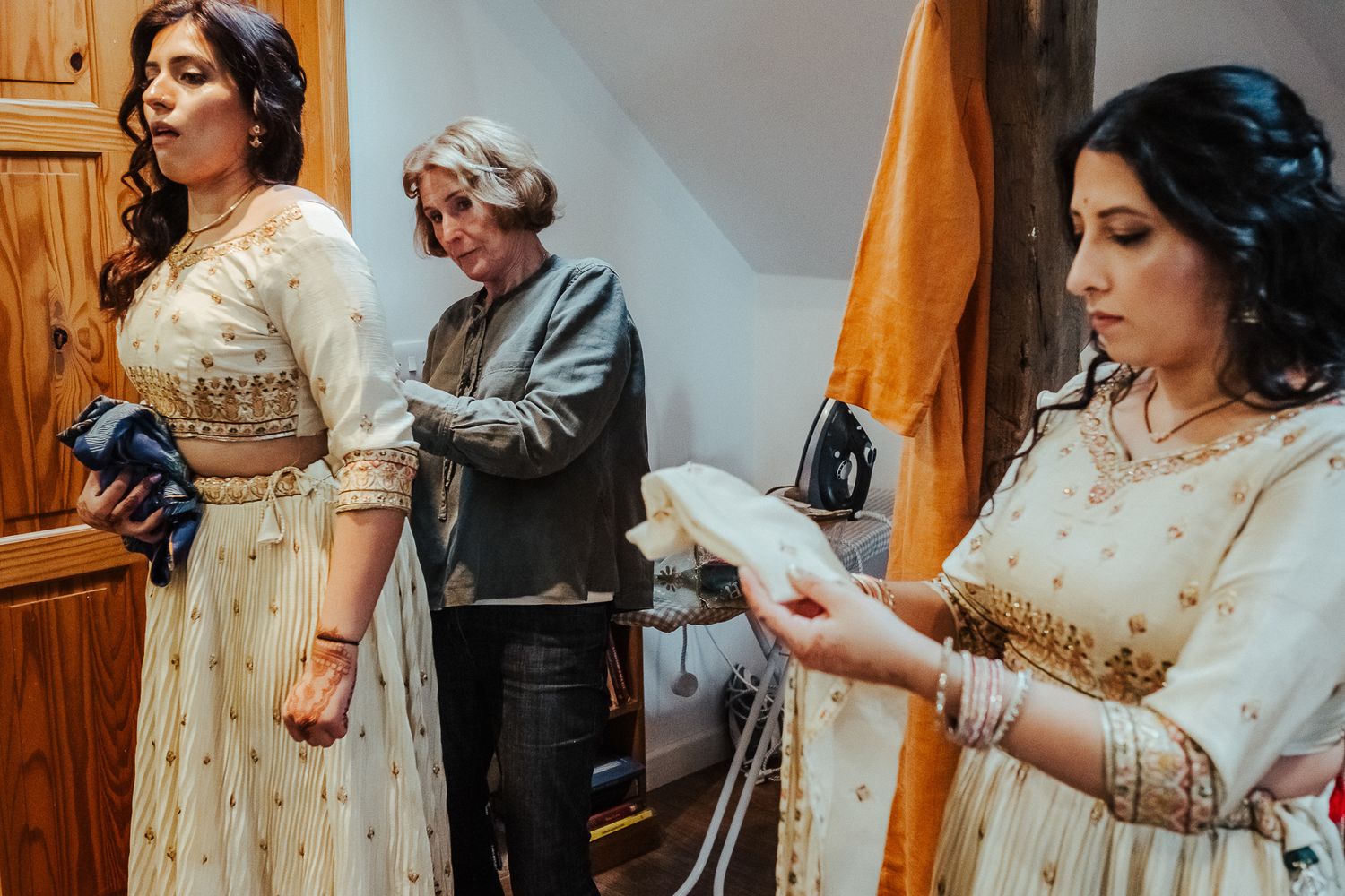 Traditional celebration with people wearing ornate dresses and accessories indoors.