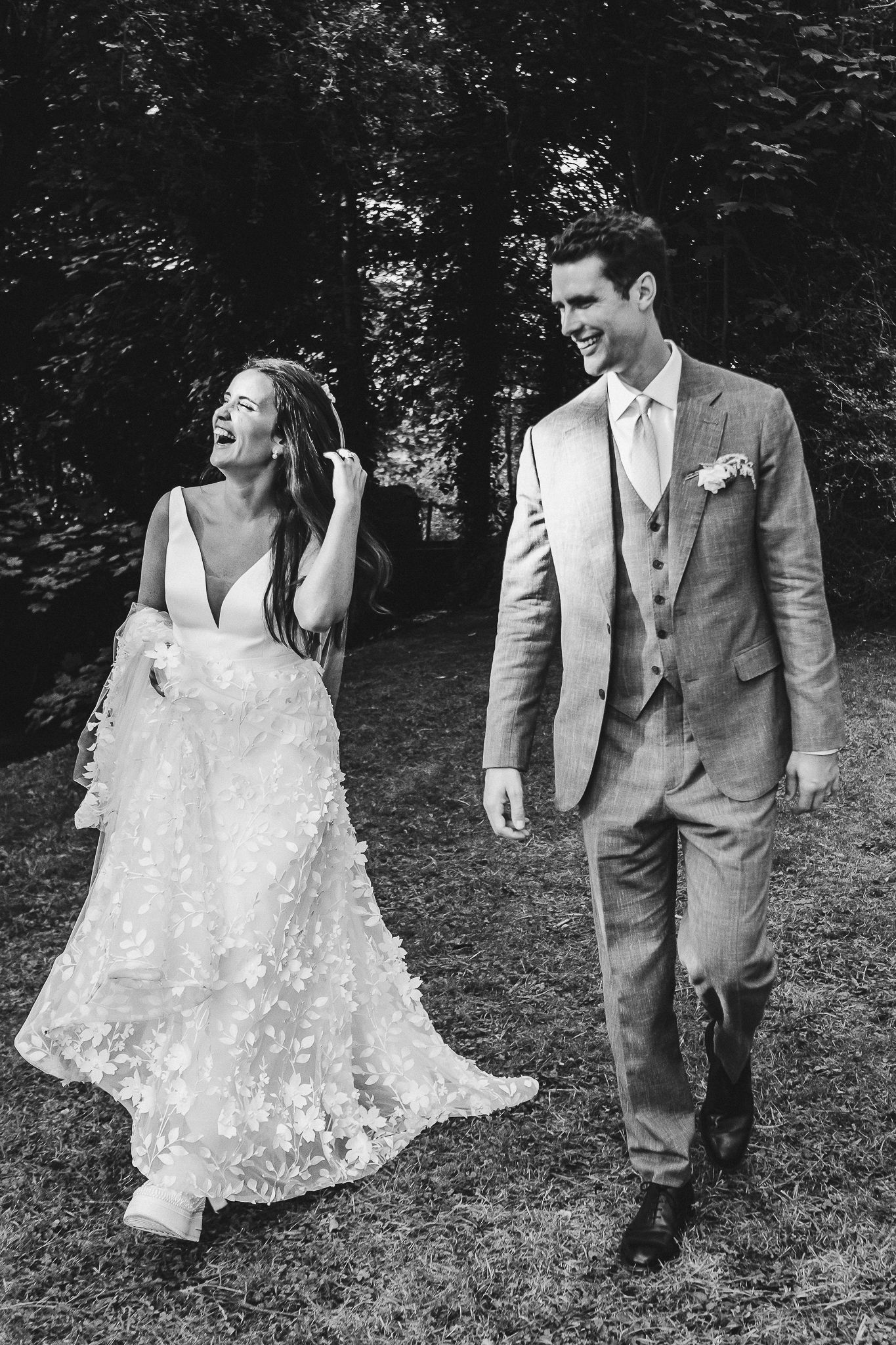 A black and white series of artistic wedding portraits featuring a couple walking through a wooded area.