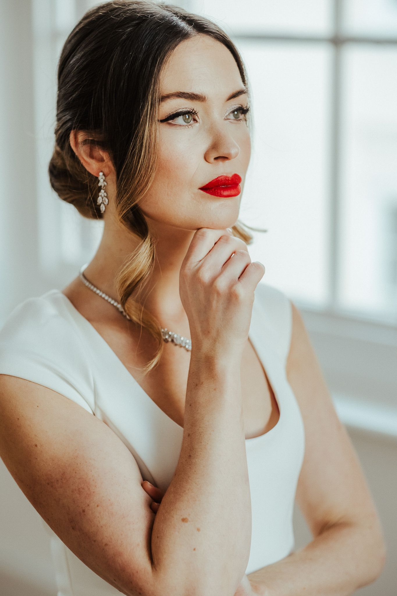Elegant bridal portrait series showing close-up details of classic updo hairstyle, red lipstick and delicate jewelry.