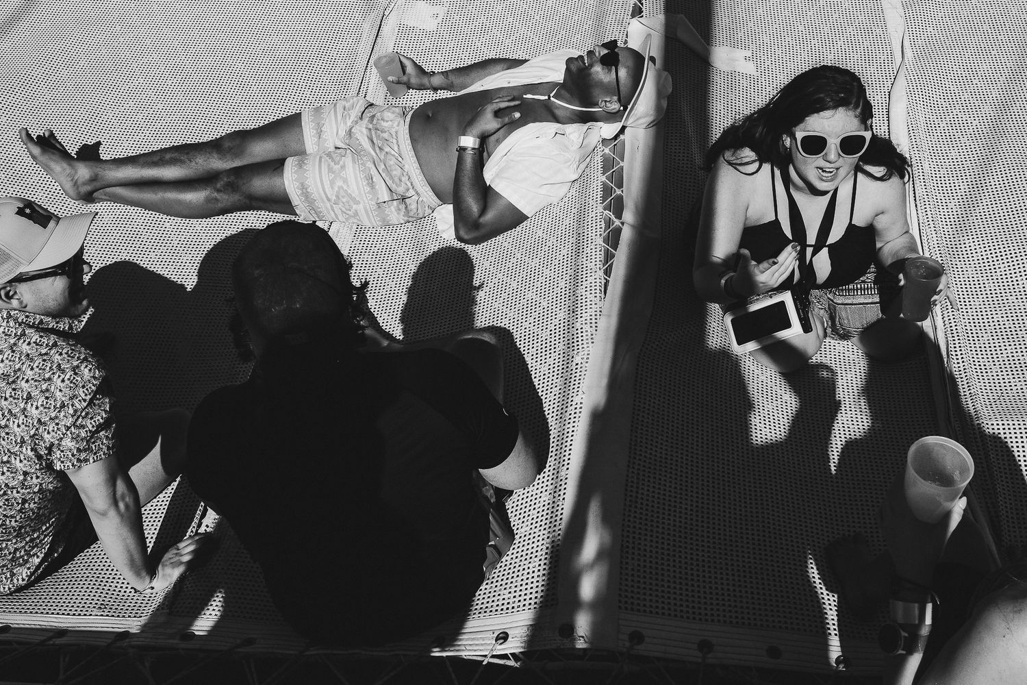 Black and white photographs showing people in silhouette against bright backgrounds creating dramatic contrast.