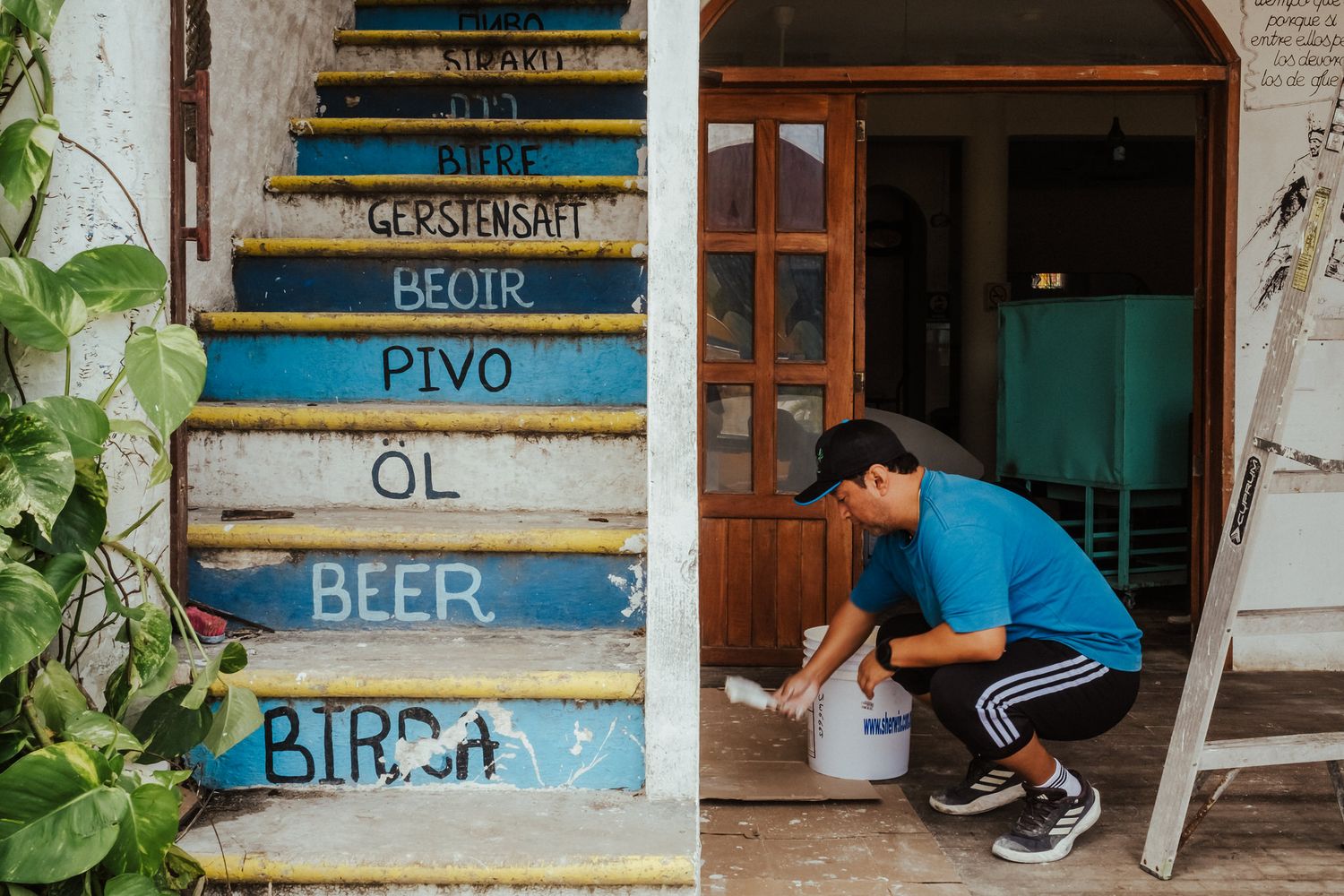A series of rustic wooden signs with blue and white text displaying words like 'Beer' and 'Beach' mounted on a wall.