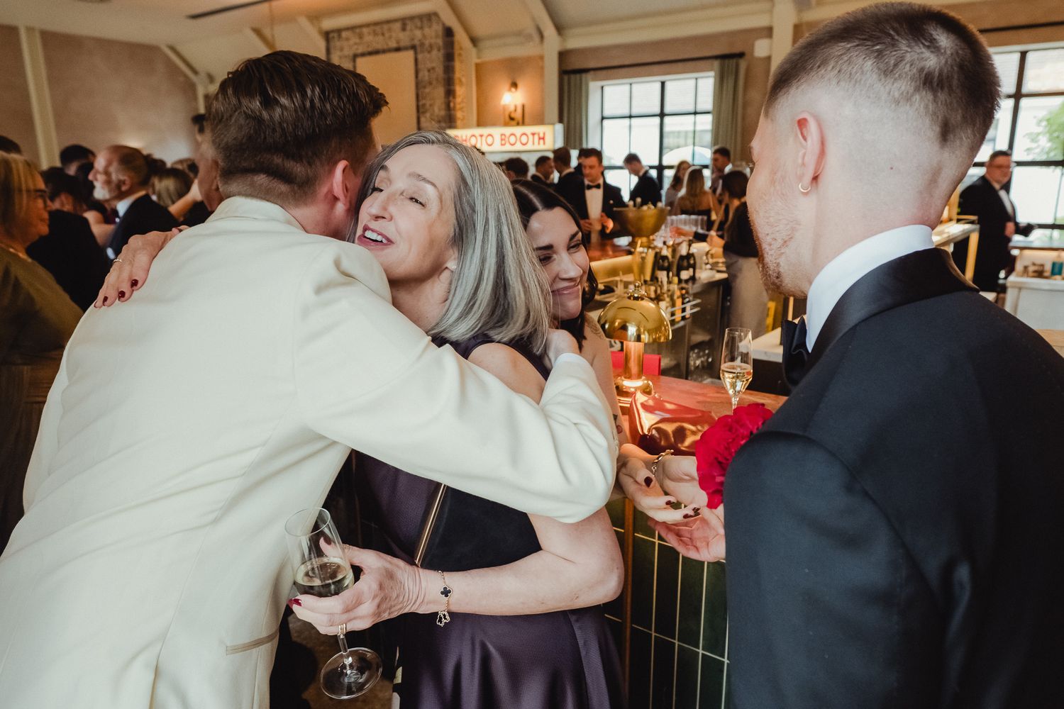 Wedding guests dance and celebrate together at an indoor reception venue during a festive celebration.