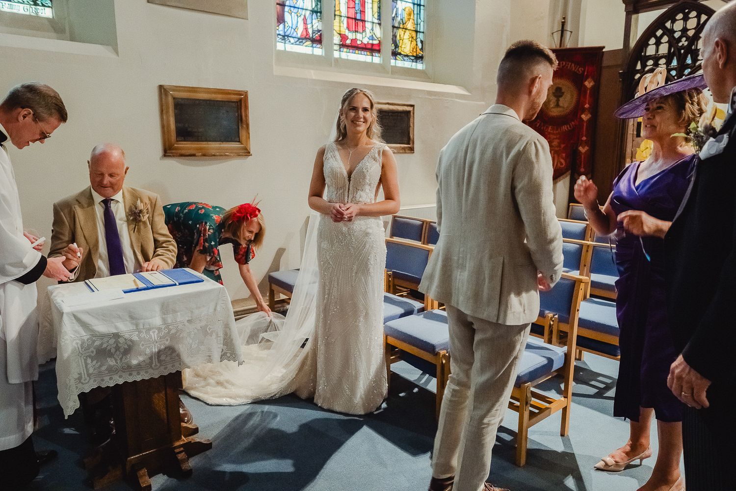 A group of people gather in a church or chapel wearing white robes for a religious ceremony or service.