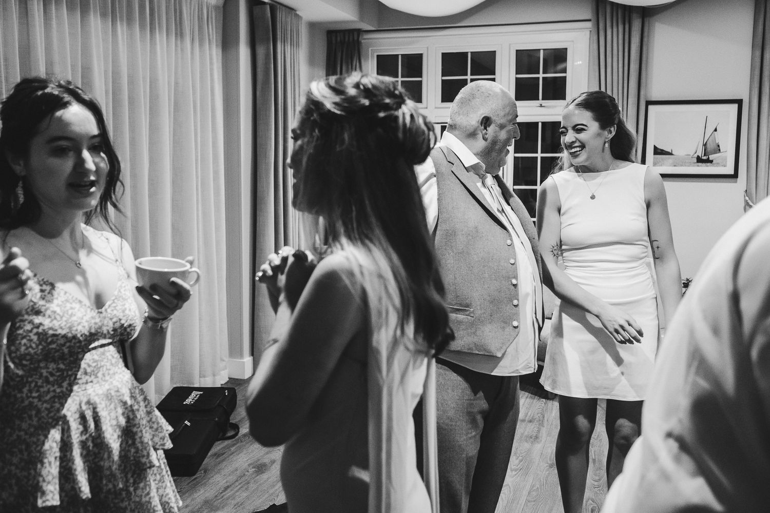 Black and white photo collage showing wedding preparation moments with people getting ready in various indoor settings.