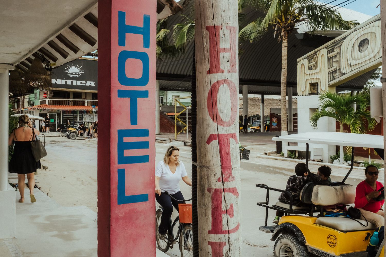 A series of connected images showing people and vehicles at a beach-side location with pink pillars in a tropical setting.