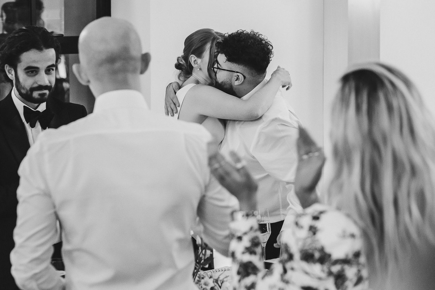 A black and white collage of wedding moments showing couples embracing and dancing at a reception celebration.