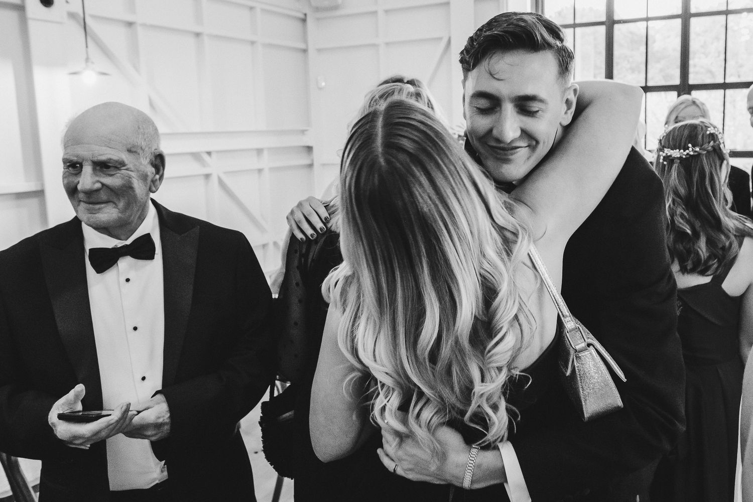 A black and white photo collage showing candid wedding moments with guests and wedding party members at a celebration.