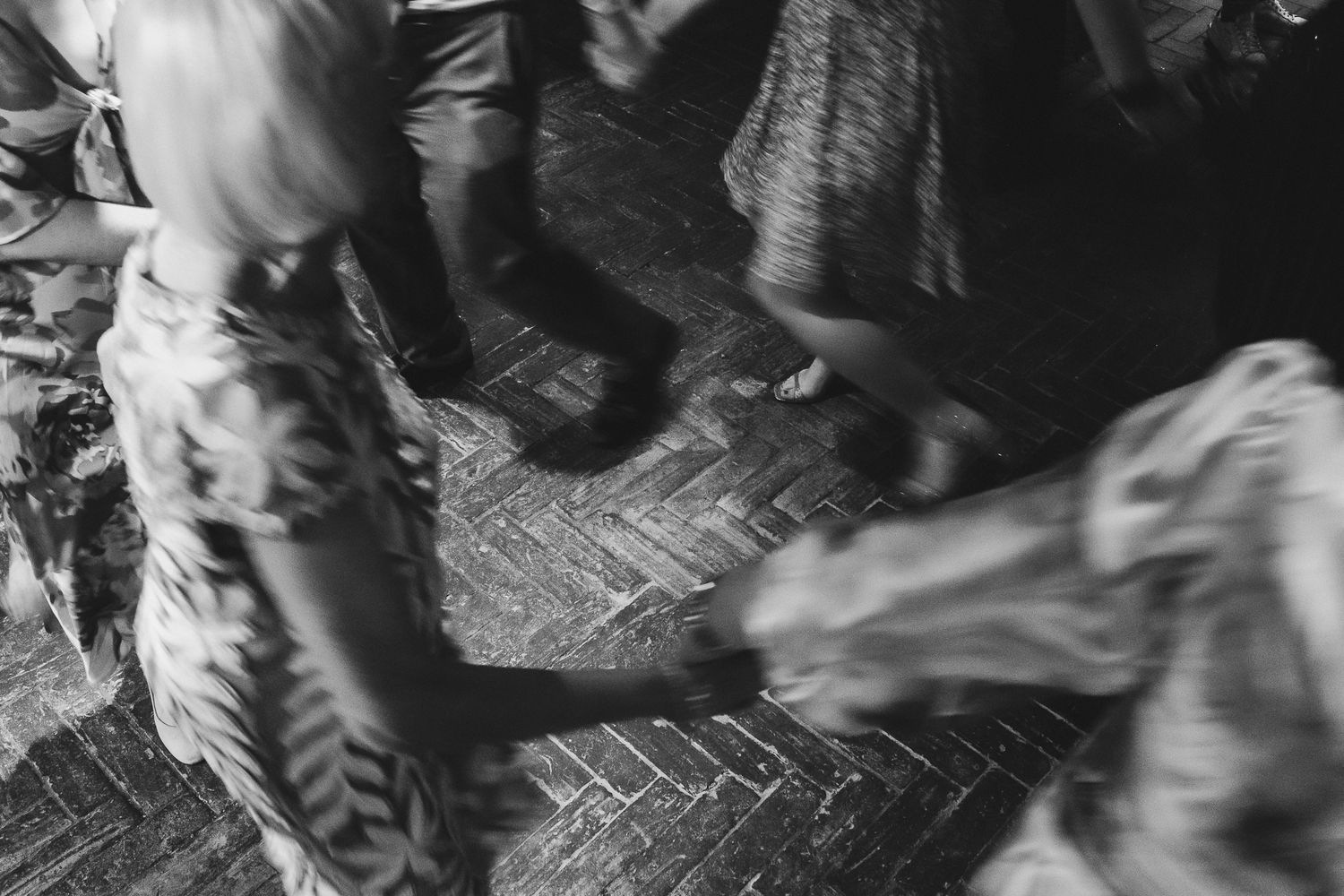 A black and white photo showing people dancing on a dance floor with motion blur effects.