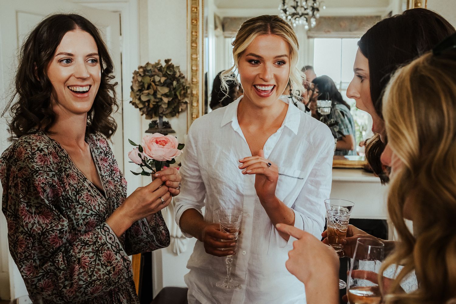 Bridesmaids sharing champagne and laughter during pre-wedding preparations.
