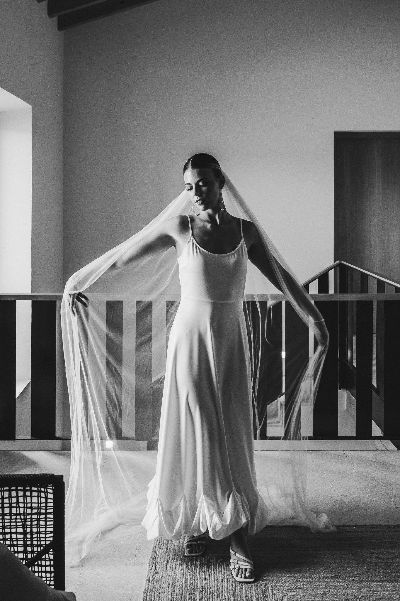 A haunting black and white triptych shows a ghostly figure in flowing white fabric moving mysteriously through an empty room.