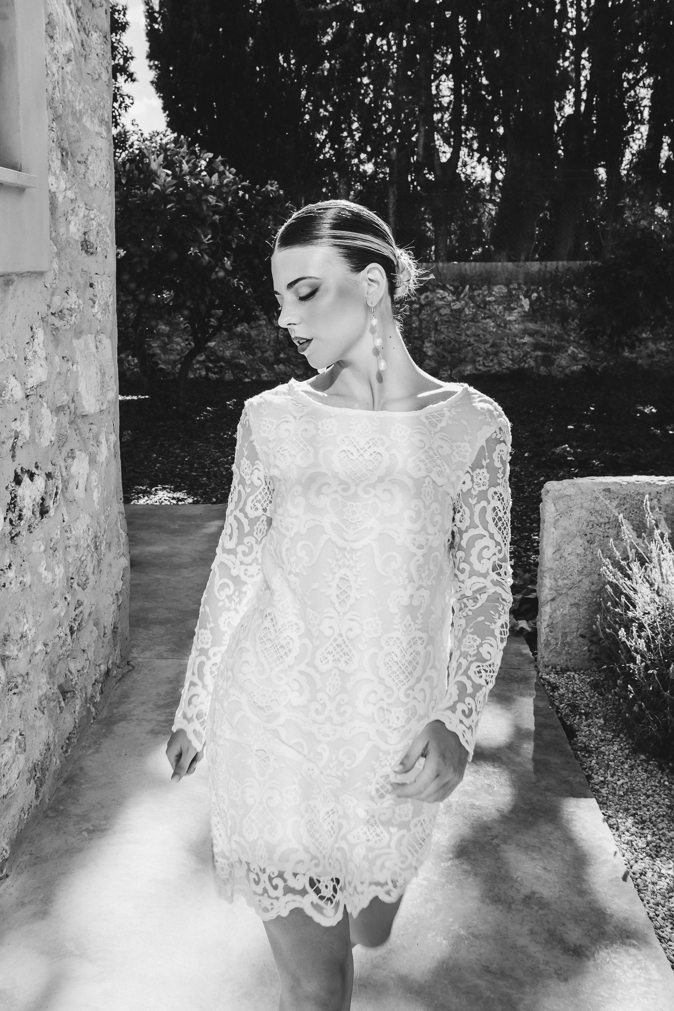 A black and white photo series showing a person in delicate white lace against a natural outdoor backdrop.