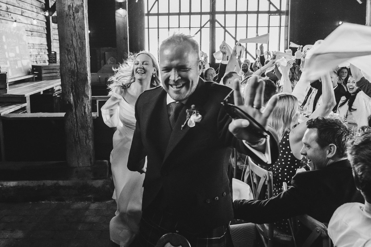 Black and white candid wedding reception photos showing joyful moments of dancing and celebration.
