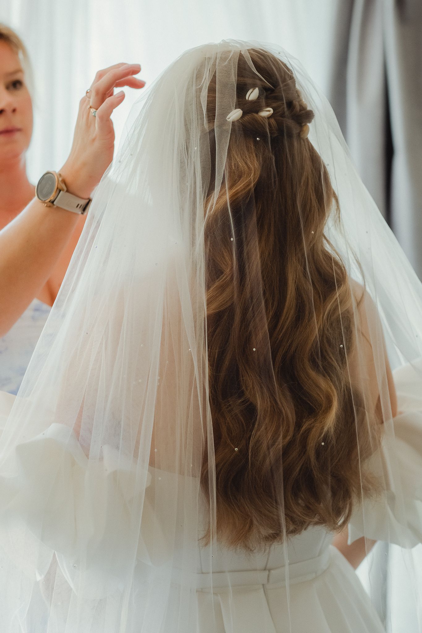 A bride wearing a white veil shows off her shoulder-length wavy brown hair from multiple angles.