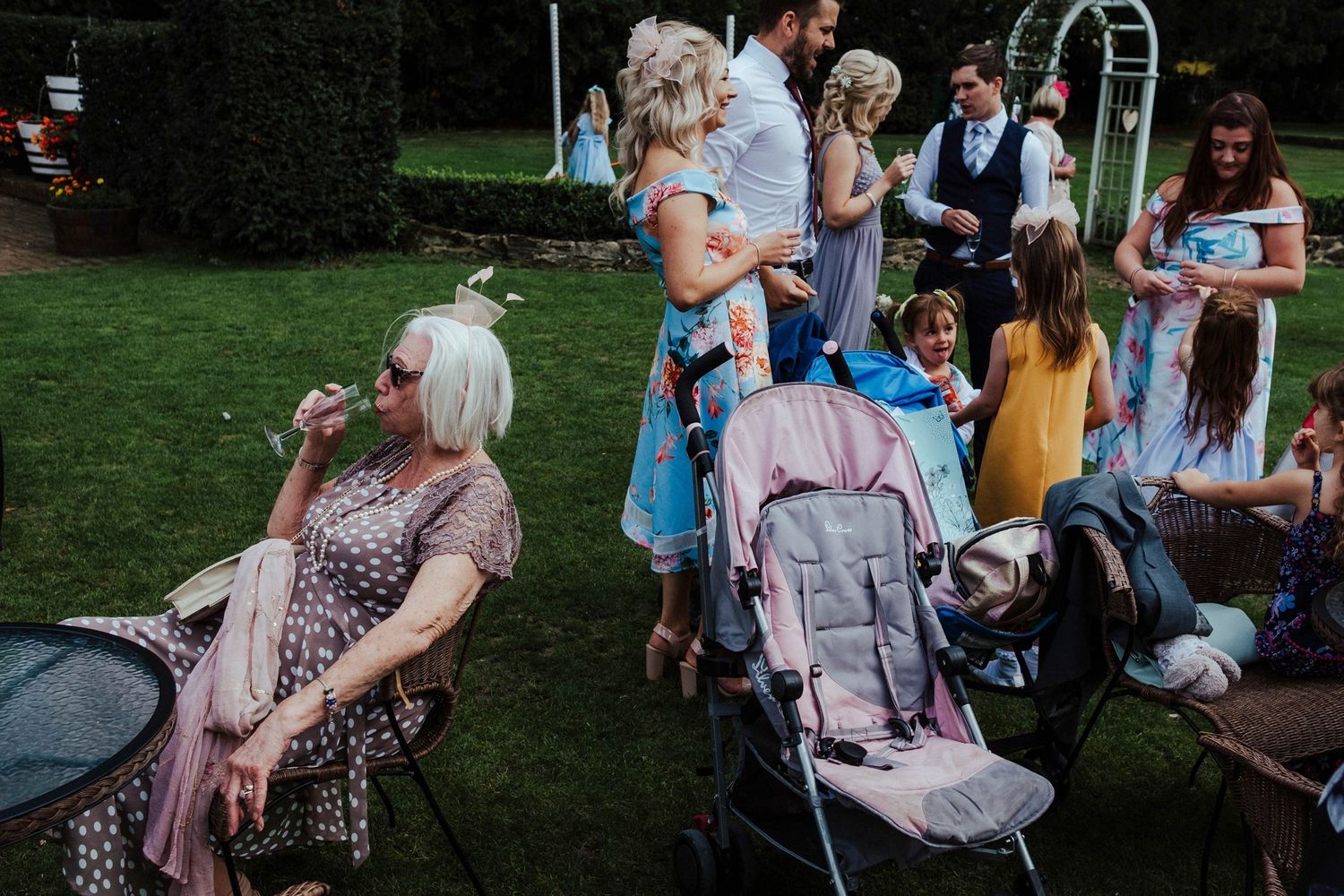 Wedding guests relax on the lawn during an outdoor garden reception.