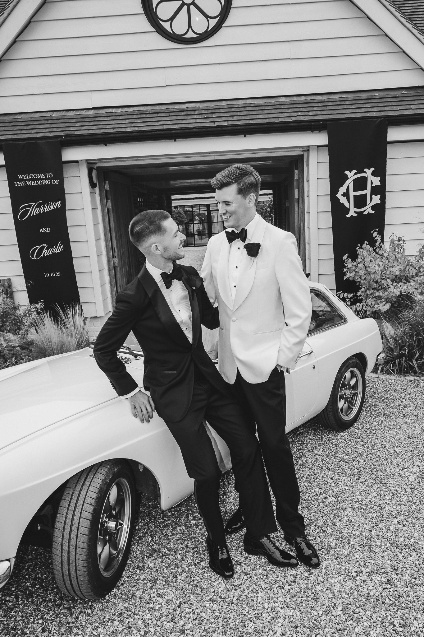 Black and white photo series of people in formal attire laughing together while standing next to a classic white car.