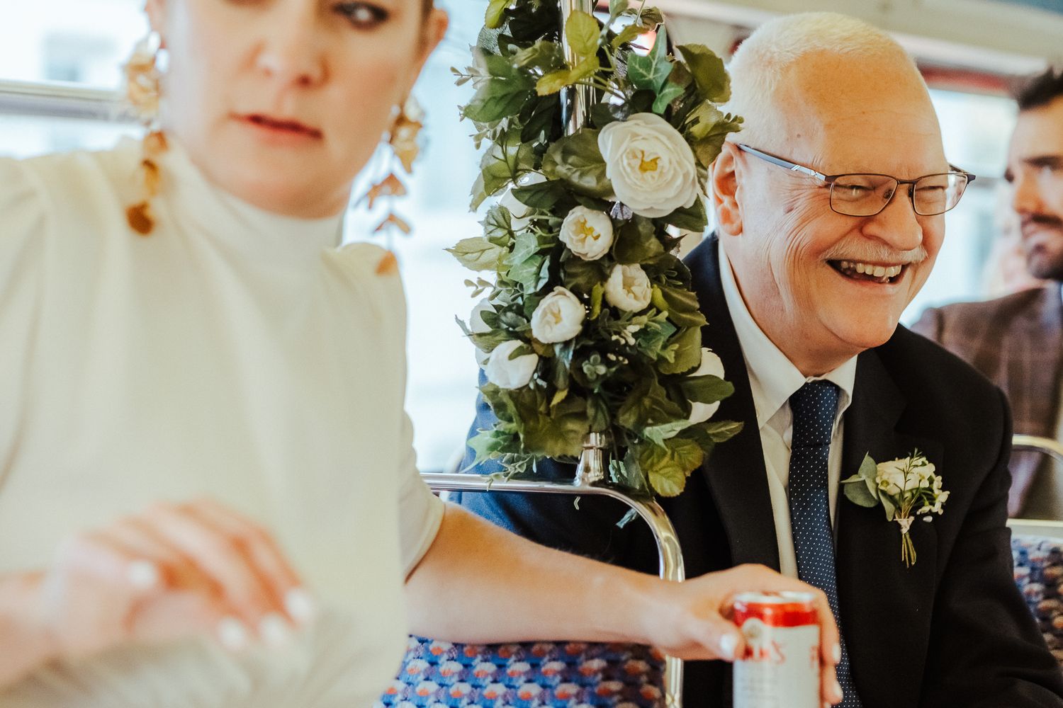 Wedding reception guests enjoy champagne and conversation at tables decorated with elegant white floral centerpieces.
