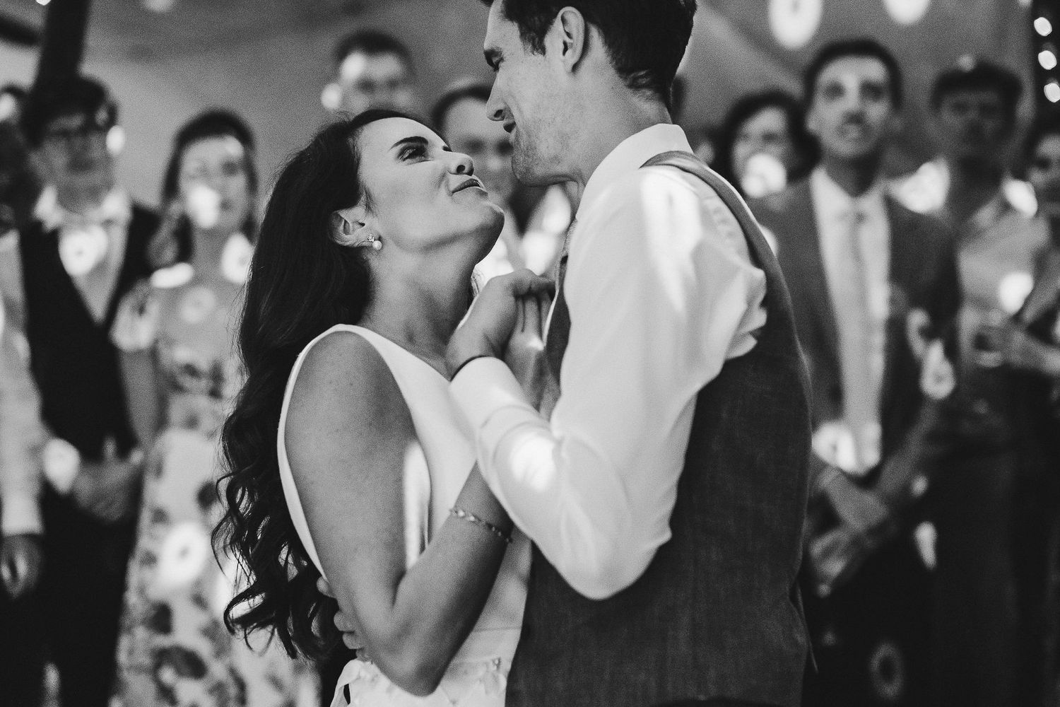 Romantic dance moment at an elegantly lit wedding reception.