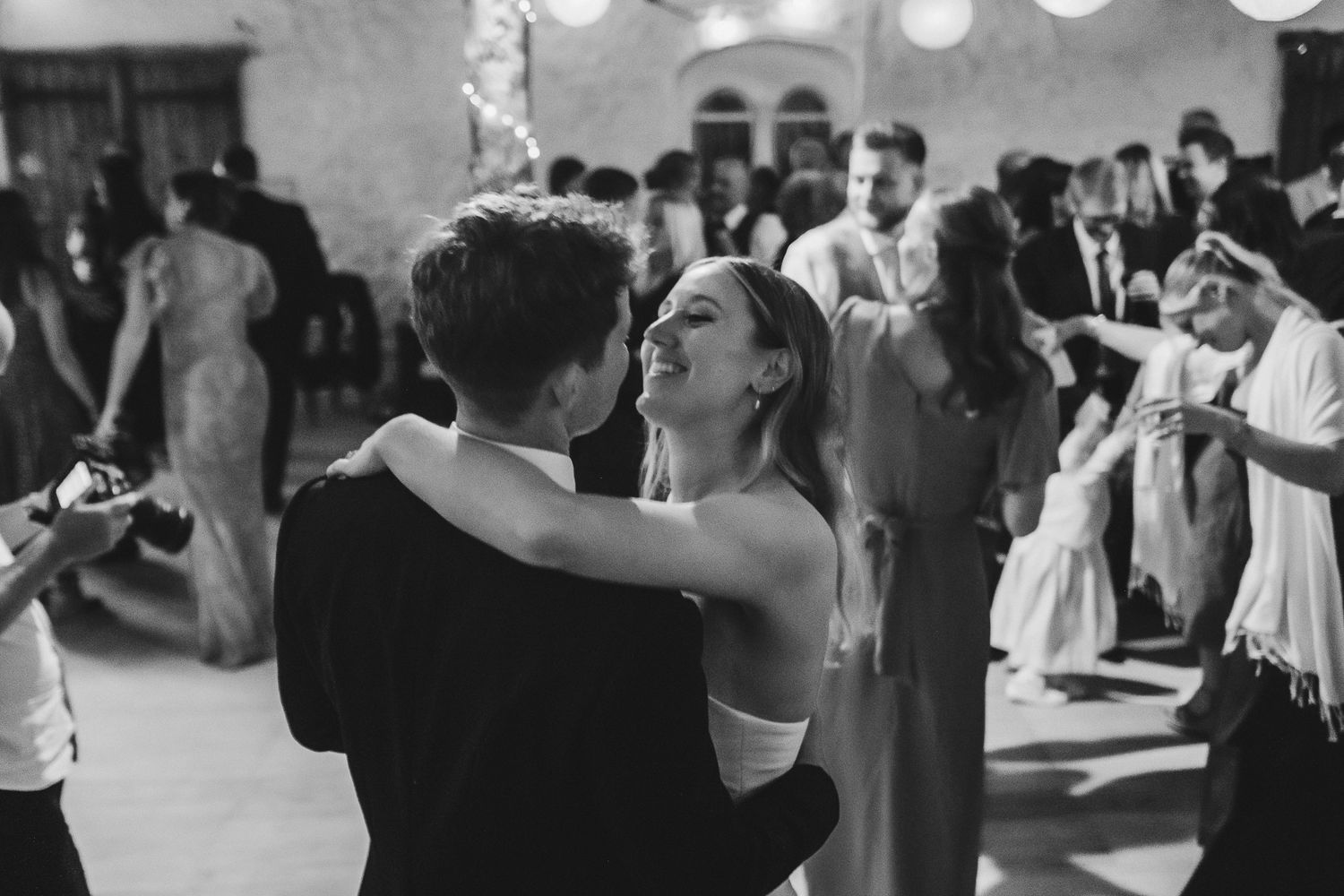 Black and white wedding reception photo showing couples dancing together on a dance floor at a celebration.