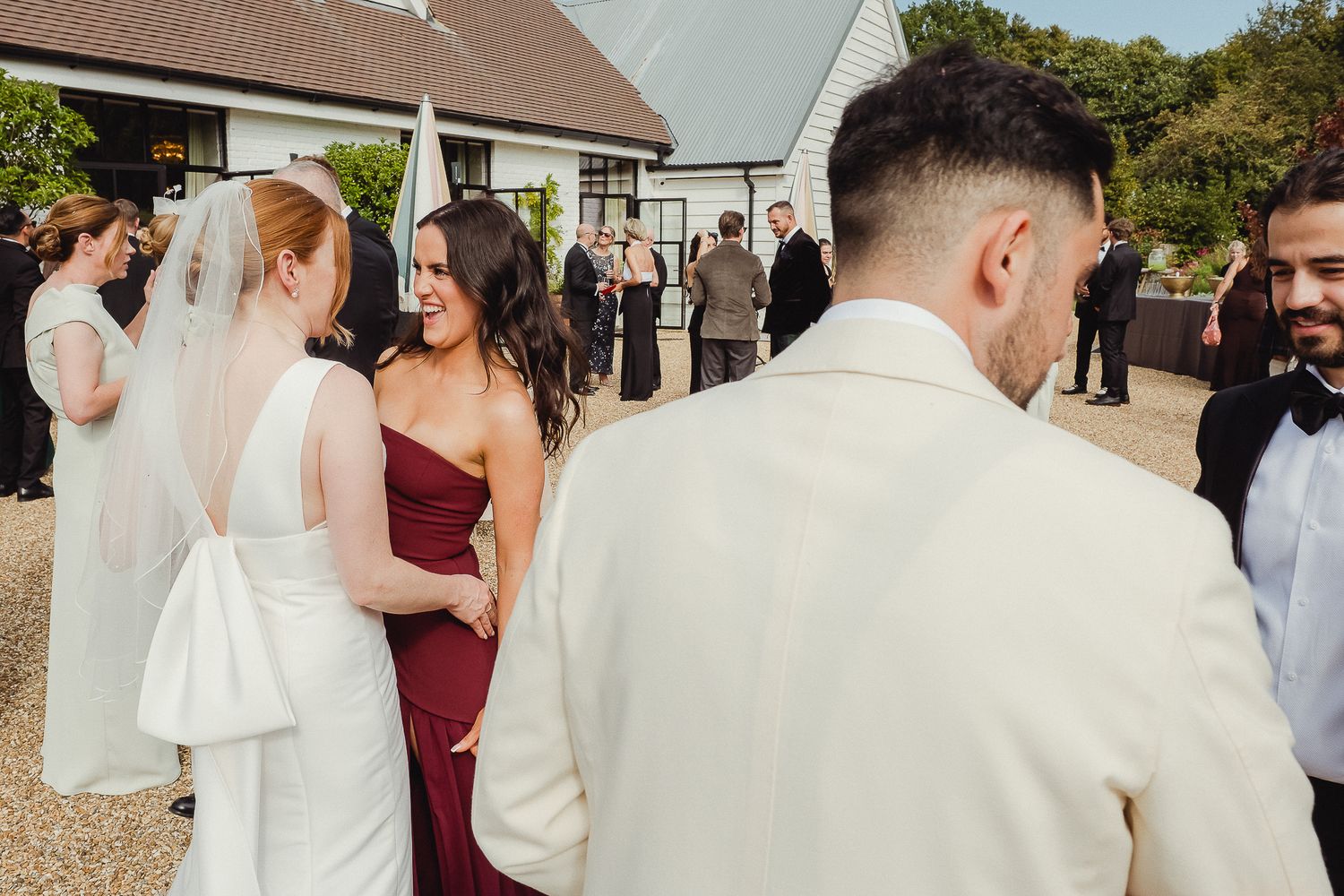 Wedding guests share emotional embraces and congratulations during an outdoor reception celebration.