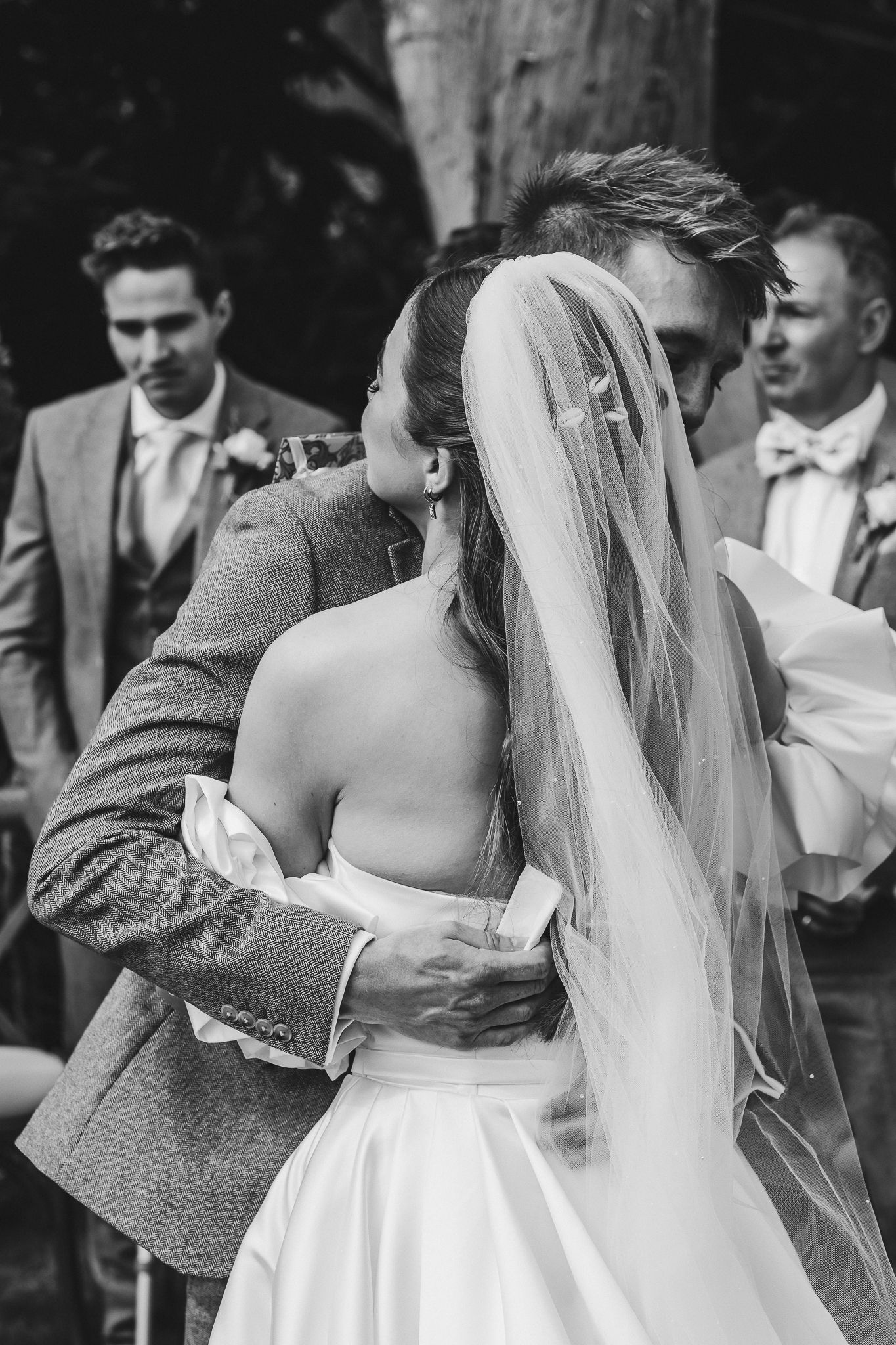 Black and white photo series showing romantic wedding moments with a bride in white dress and veil dancing with a partner.