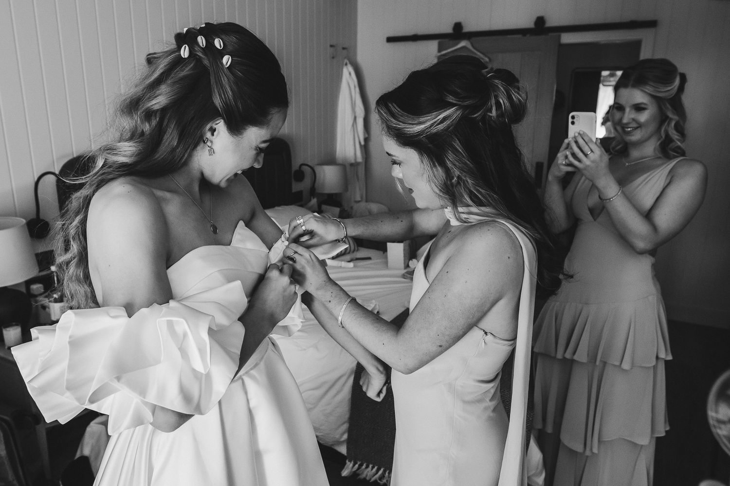 Black and white photo collage showing wedding preparation moments with bridesmaids getting ready in dresses.