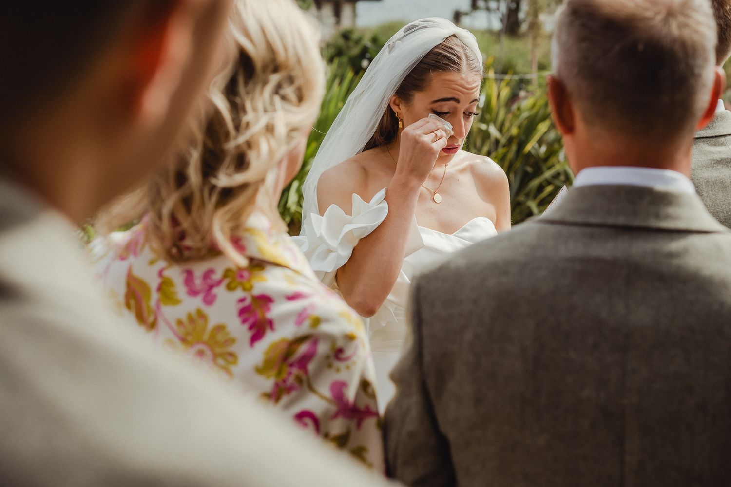 A wedding couple shares a tender moment during their ceremony as they exchange vows outdoors.
