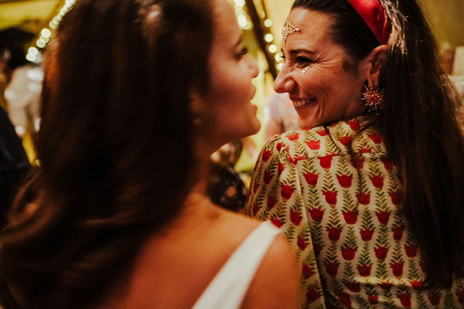 Two people share a joyful moment while dancing at a wedding celebration.