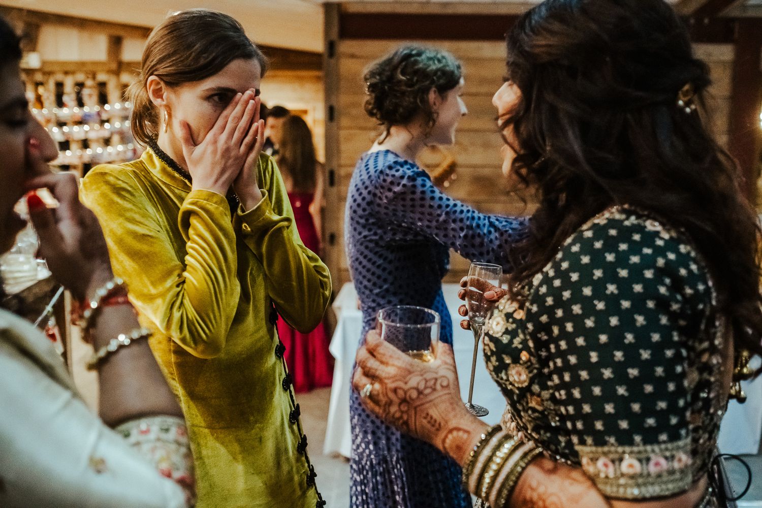 Guests in colorful attire share emotional moments during a celebration.