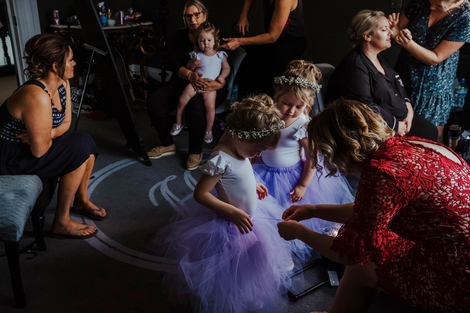 Young children in formal attire play and dance on the reception floor.