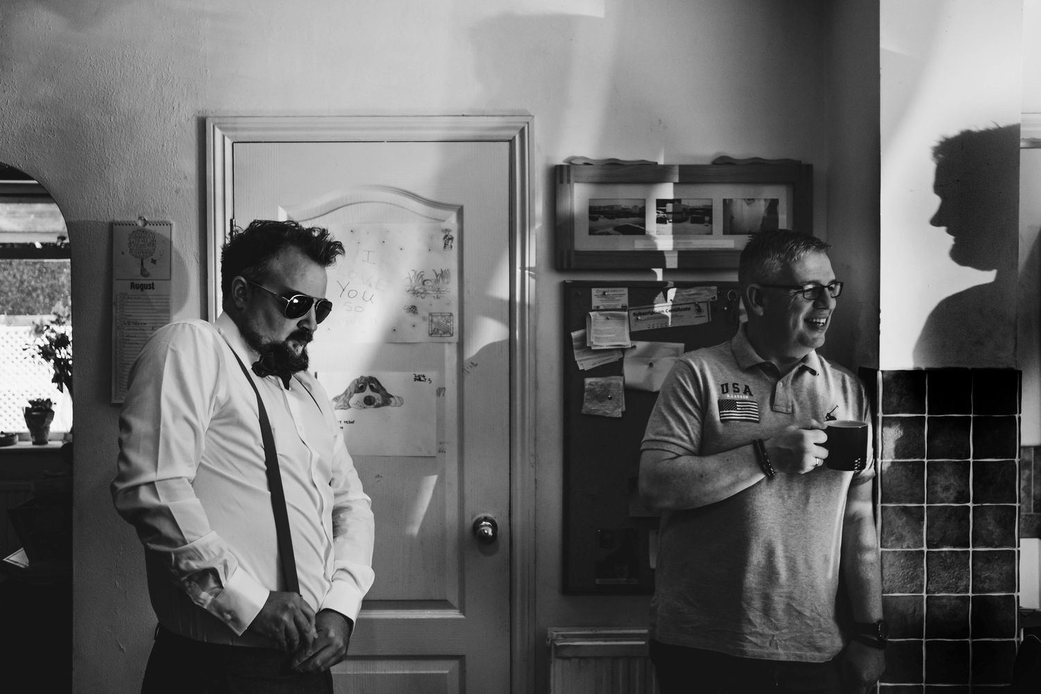 Two figures sharing a candid moment in black and white photography.