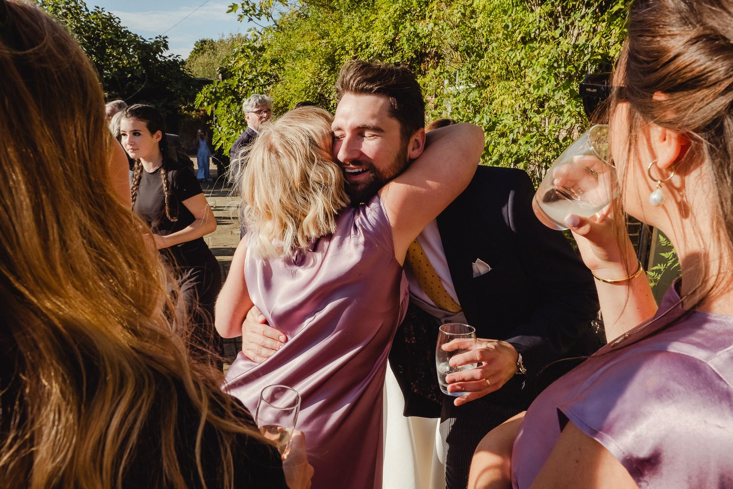 People celebrating and dancing at an outdoor party on a sunny afternoon.