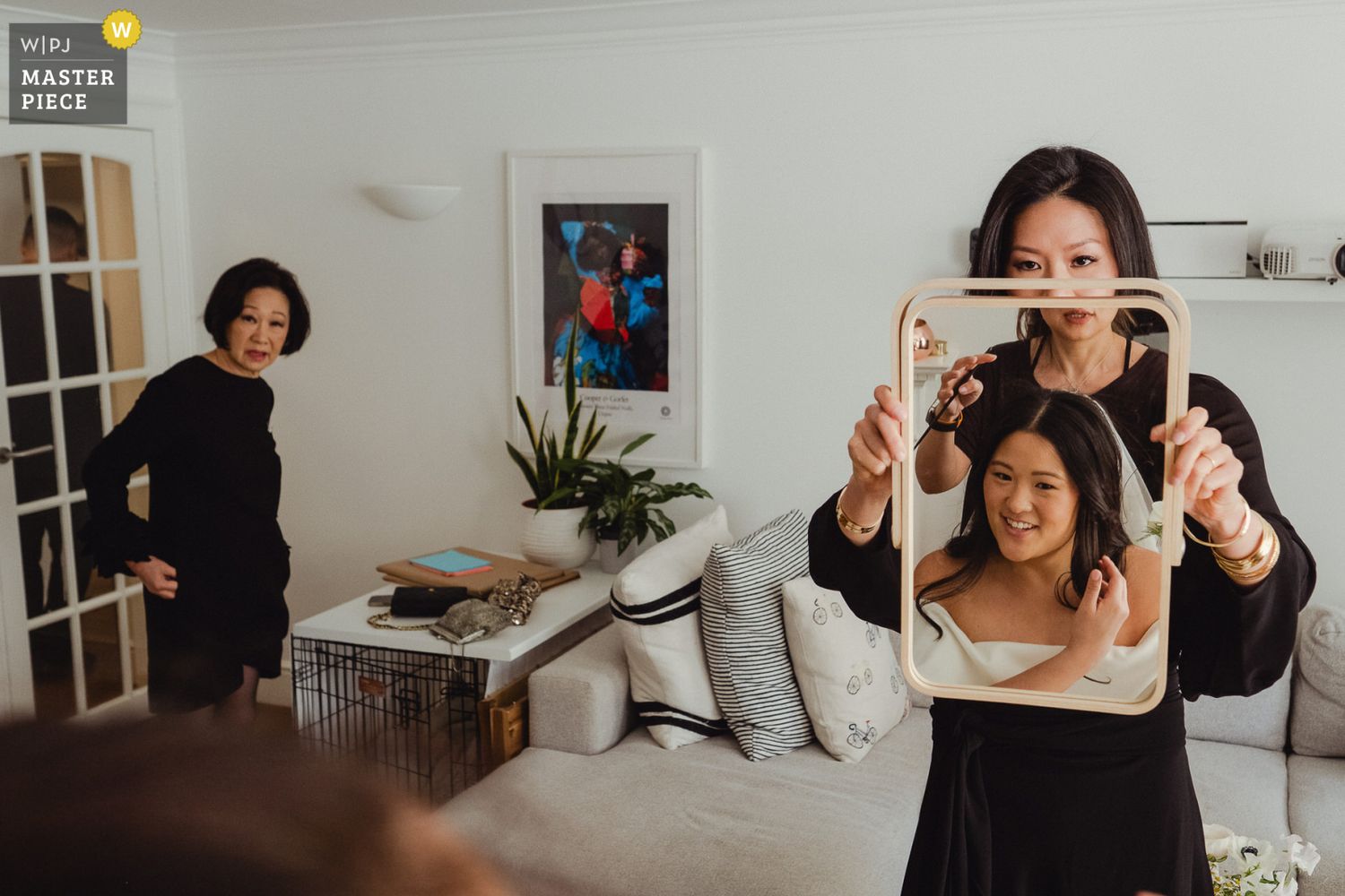People in a living room having fun with creative photo framing while taking pictures together.