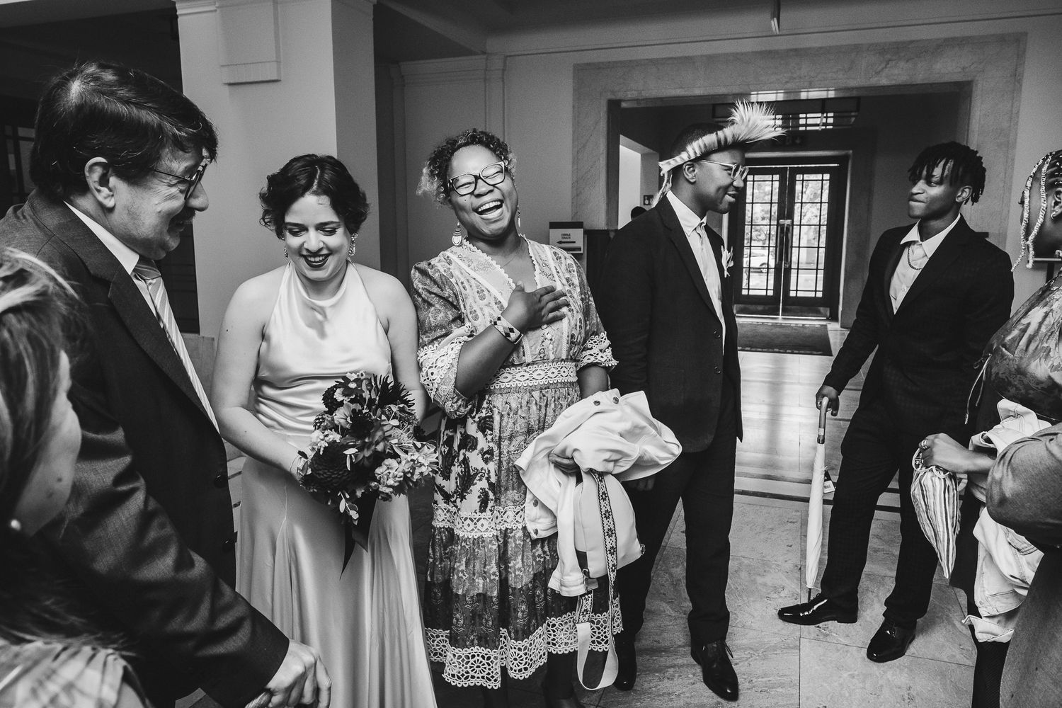 Black and white photos showing candid wedding moments with guests and family celebrating at a reception.