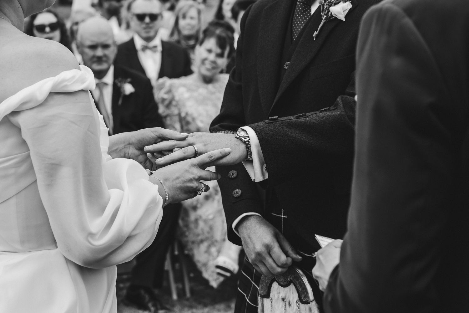 Black and white photos of wedding guests celebrating and interacting during an outdoor reception.