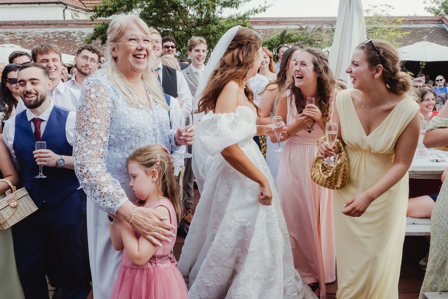 A group of wedding guests dance and celebrate together on a festive dance floor during a reception party.