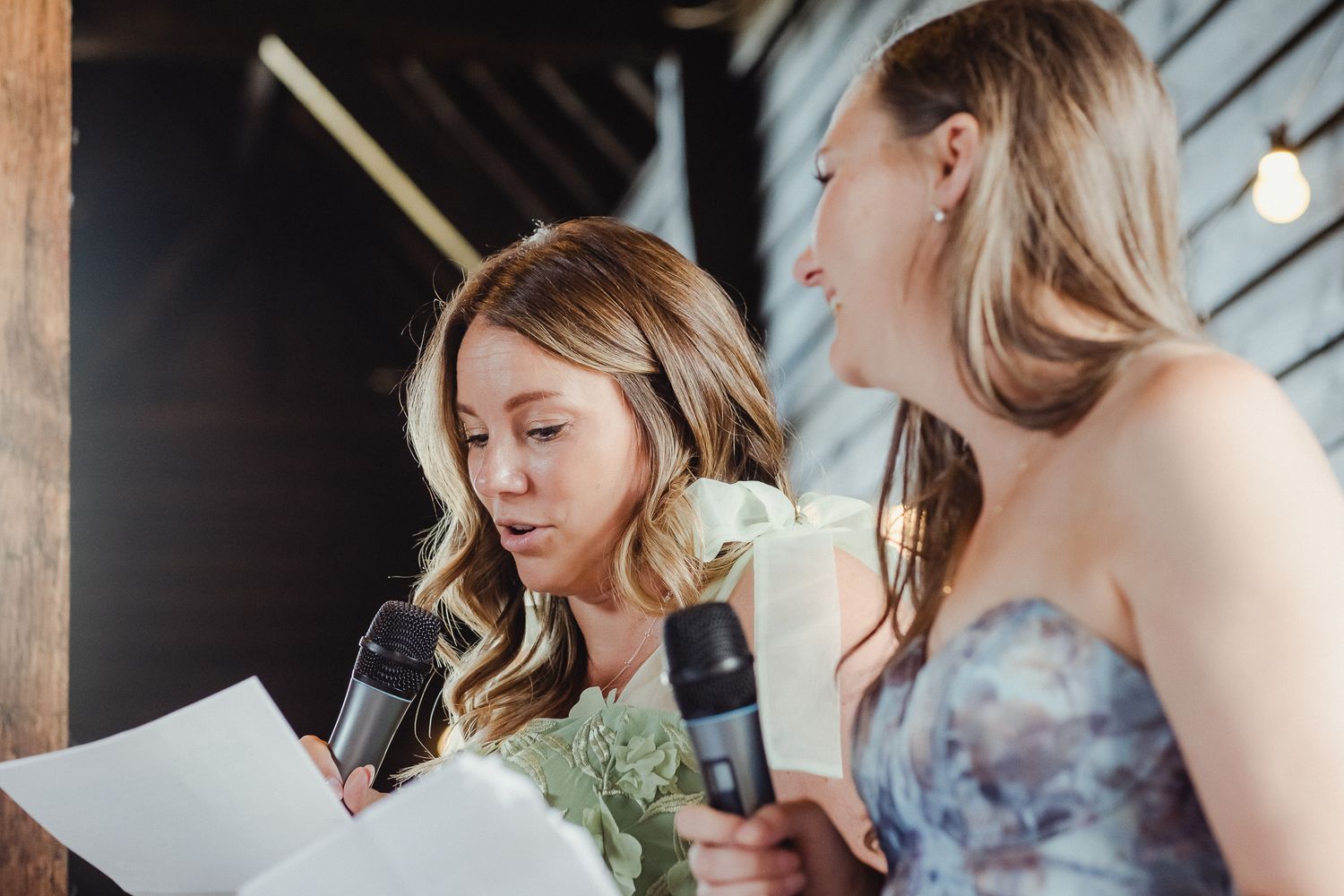 A group of people enjoying drinks and conversation at an elegant indoor event space with rustic decor.