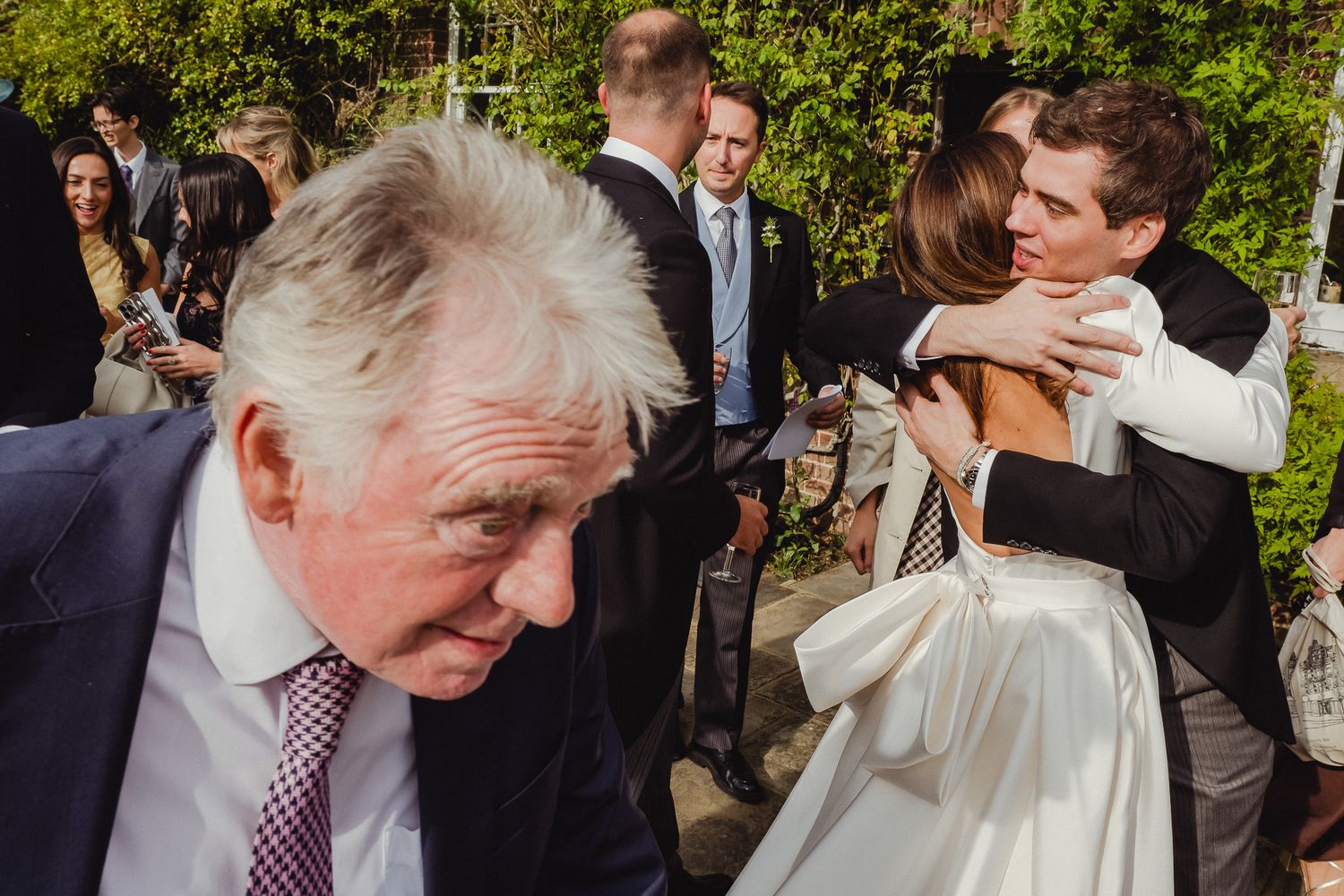 A sequence of candid wedding reception moments showing guests laughing and socializing outdoors in a garden setting.