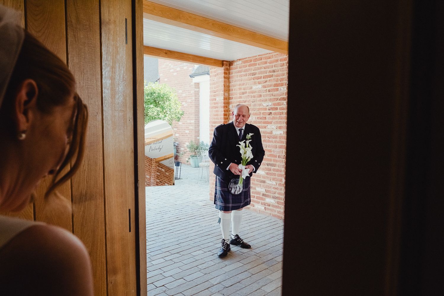 A series of intimate wedding moments captured through doorways and windows at a rustic brick venue.