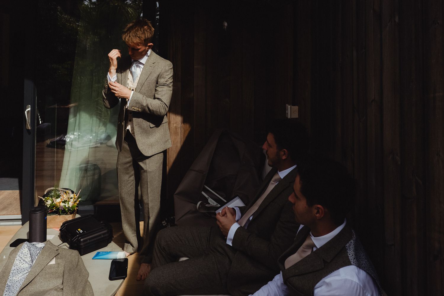 A series of professional business people presenting and collaborating during a meeting in a dark conference room.